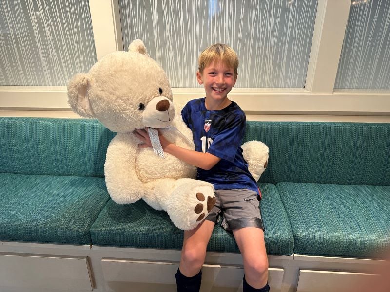 Child's first visit to dentist posing with our large teddy bear