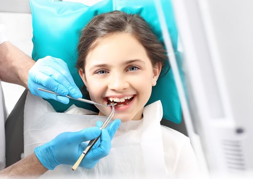 girl getting her teeth cleaned at the dentist