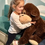 little girl hugging stuffed bear at the dentist