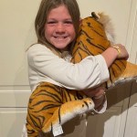 little girl holding stuffed tiger