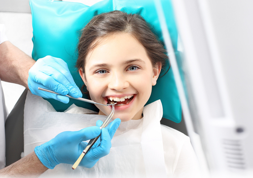 girl getting her teeth cleaned at the dentist